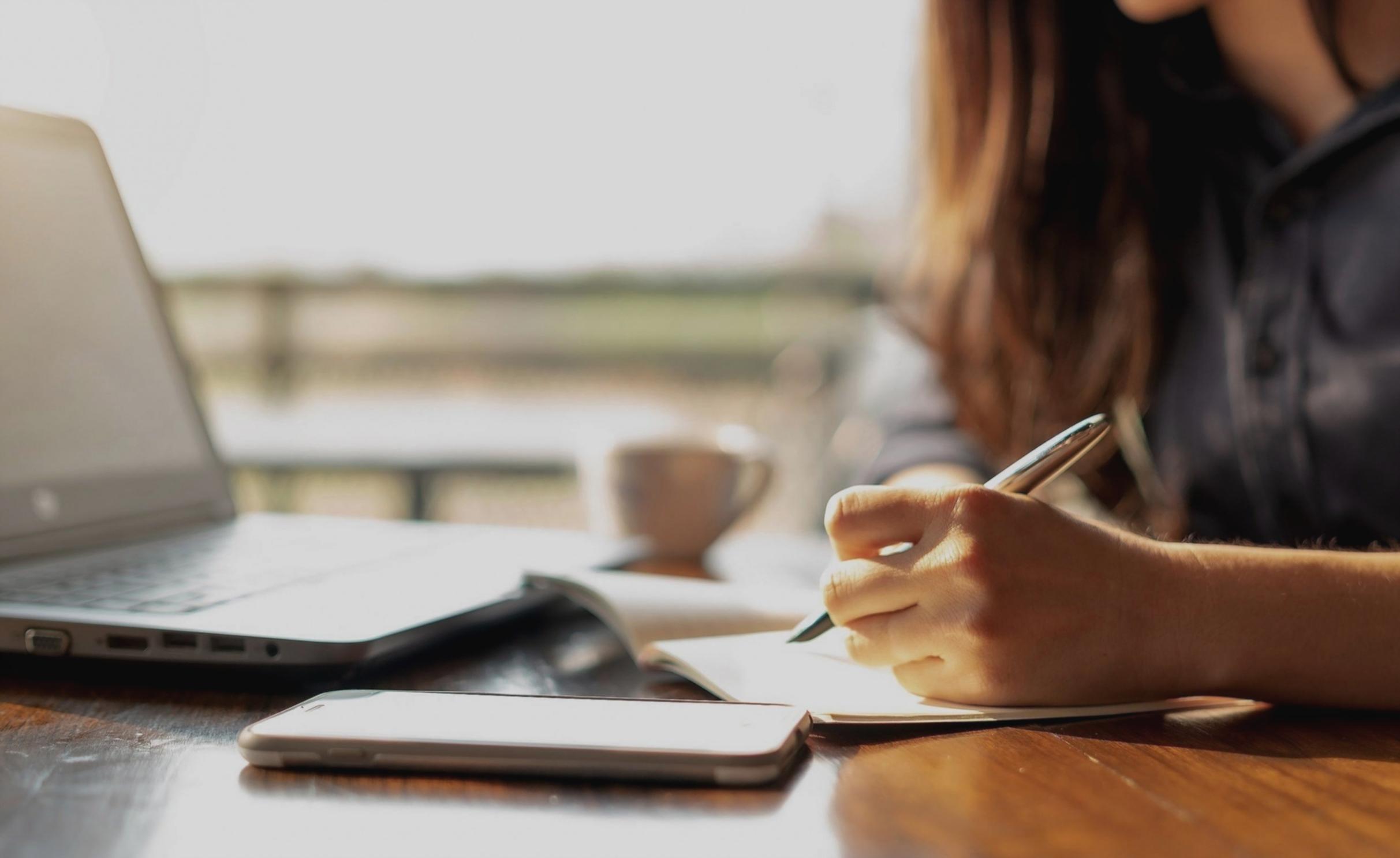 Parent and teenager discussing financial concepts with laptop open